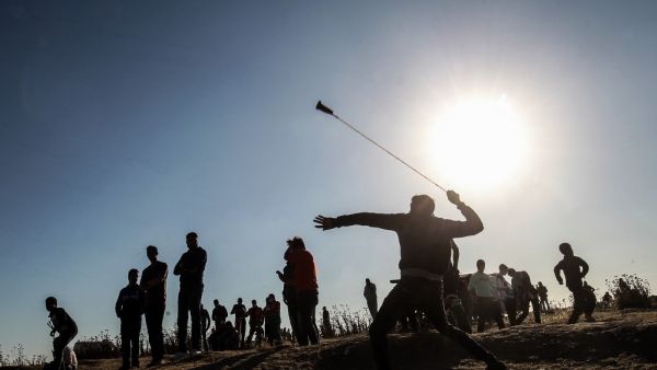 A Palestinian protester hurls stones at Israeli troops during a demonstration near the border with Israel, east of Gaza City, on May 10, 2019. (Said KHATIB / AFP)