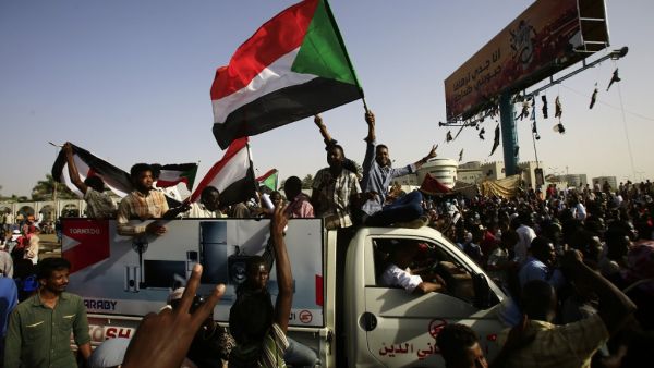 Sudanese protesters wave national flags as they gather near the military headquarters in the capital Khartoum, during a rally on April 27, 2019. AFP