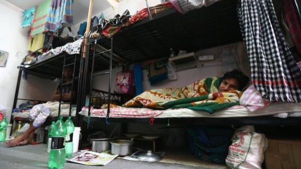 A migrant worker lays in his bunk bed inside a labor camp in Qatar (AFP/FILE/GETTY) banner image