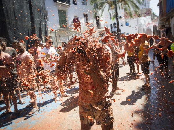 A reveller covered in tomato pulp takes part in the annual "Tomatina" festival in the eastern town of Bunol, on August 28, 2019. JAIME REINA / AFP