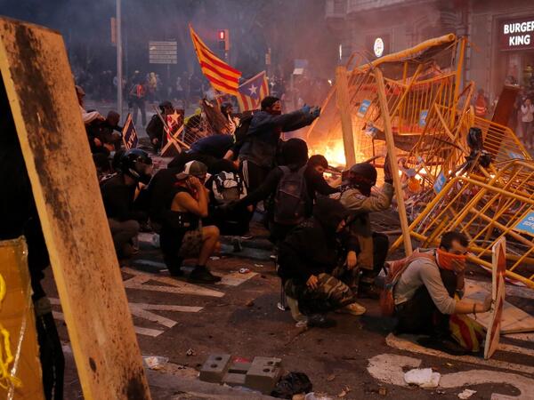 Protesters use fences as a barricade during clashes near the Police headquarters in Barcelona, on October 18, 2019, on the day that separatists have called a general strike and a mass rally. Pau Barrena / AFP