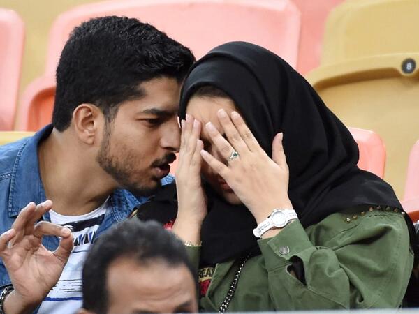 A picture taken on January 12, 2020 shows a Saudi couple attending a football match at King Abdullah Sport City Stadium in Jeddah. In Saudi Arabia's rigid past, religious police once swooped down on rose sellers and anyone peddling red paraphernalia around Valentine's Day, but now a more open -- albeit risky -- dating culture is taking root. Pursuing relationships outside of marriage in the conservative Islamic kingdom once amounted to a death wish, and would-be Romeos resorted to pressing phone numbers up 