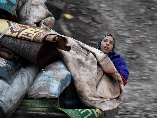 A Syrian girl rides in the back of a truck with belongings and furniture as people displaced from the south of Idlib province travelling in vehicles loaded with furniture and other belongings and fleeing from advancing government forces arrive at a camp for the internally displaced near Dayr Ballut, near the Turkish border in the rebel-held part of Aleppo province in the country's northwest on February 4, 2020. Rami al SAYED / AFP