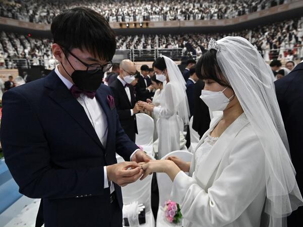 Couples wearing protective face masks attend a mass wedding ceremony organised by the Unification Church at Cheongshim Peace World Center in Gapyeong on February 7, 2020. South Korea has confirmed 24 cases of the SARS-like virus so far and placed nearly 260 people in quarantine for detailed checks amid growing public alarm. Jung Yeon-je / AFP