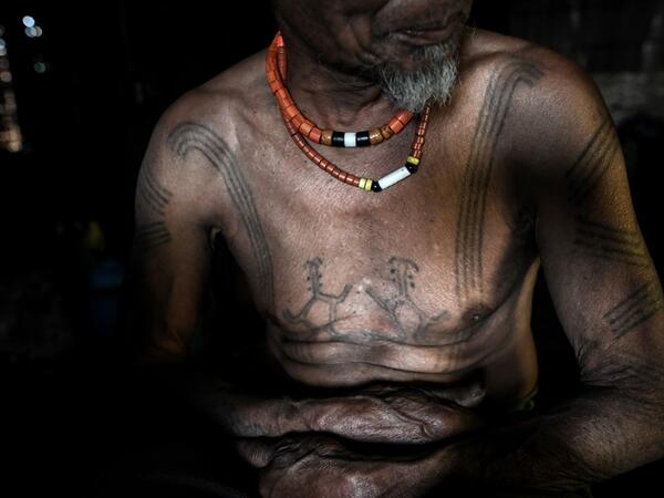 This photo taken on February 6, 2020 shows Ngon Pok, 80, a tattooed Lainong tribesman, at his house at Lahel township in Sagaing region of Myanmar, wedged in a semi-autonomous zone near the Indian border. People in the region subscribe to a complex patchwork of customs, intertwining their animist beliefs with warrior traditions that include striking tattoo designs, which can signify tribal identity, life accomplishments or the completion of a rite of passage. Ye Aung THU / AFP