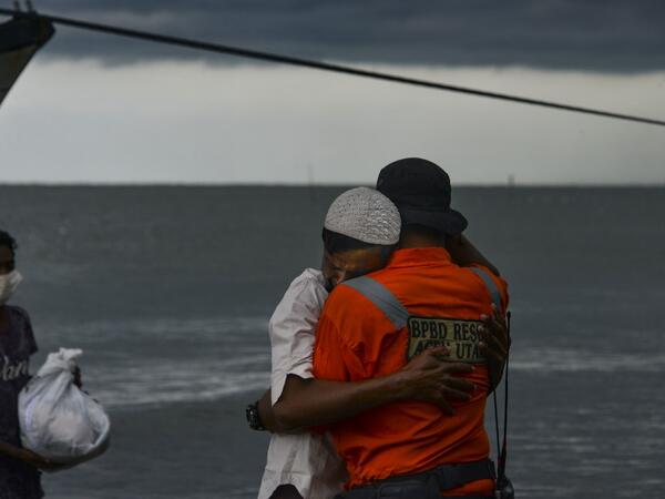 A Rohingya man from Myanmar hugs an Indonesian officer after being evacuated from a boat onto the shorelines of Lancok village, in Indonesia's North Aceh Regency on June 25, 2020. Nearly 100 Rohingya from Myanmar, including 30 children, have been rescued from a rickety wooden boat off the coast of Indonesia's Sumatra island, a maritime official said. CHAIDEER MAHYUDDIN / AFP