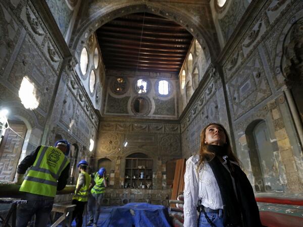 Rania Kataf, 35-year-old Syrian, walks past restoration workers at a palatial Ottoman-era home called Beit al-Quwatli for her digital archive in the old part of Syria's capital Damascus on November 11, 2020. LOUAI BESHARA / AFP