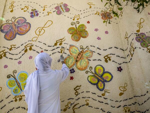 This picture taken during a government-guided tour on December 27, 2020 shows an inmate drawing a mural on a wall at al-Qanatir women's prison, at the tip of the Nile delta in Qalyoubiya province, about 30 kilometres north of Egypt's capital. Khaled DESOUKI / AFP
