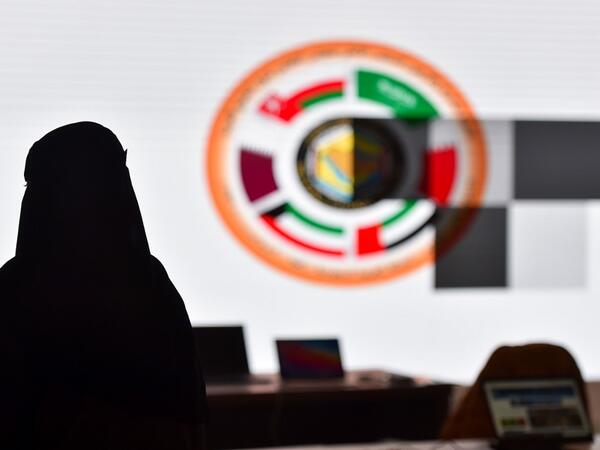 A Saudi journalist is pictured in front of the logo of the Gulf Cooperation Council (GCC) at the media centre ahead of the 41st summit in the city of Al-Ula in northwestern Saudi Arabia on January 5, 2021. FAYEZ NURELDINE / AFP