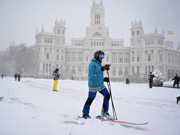 A man skis in Cibeles square amid a heavy snowfall in Madrid on January 9, 2021. Heavy snow fell across much of Spain, leaving huge areas blanketed in white as Storm Filomena brought wintry weather not seen in decades to the Iberian peninsula. GABRIEL BOUYS / AFP