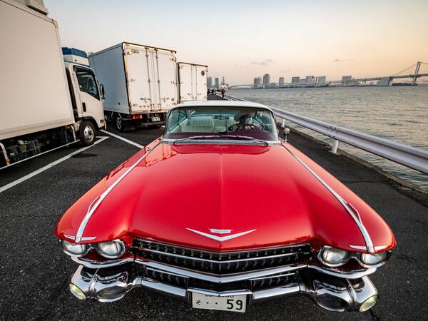 This picture taken on January 16, 2021 shows Hiroyuki Wada, who runs a vintage car service company, sitting in a 1959 Cadillac Coupe DeVille after a gathering of auto enthusiasts in Tokyo. A loose club of fans rolls up most weekends in central Tokyo to show off their Cadillacs, Chevrolets and other modern classic vehicles from the mid to late 20th century. Philip FONG / AFP