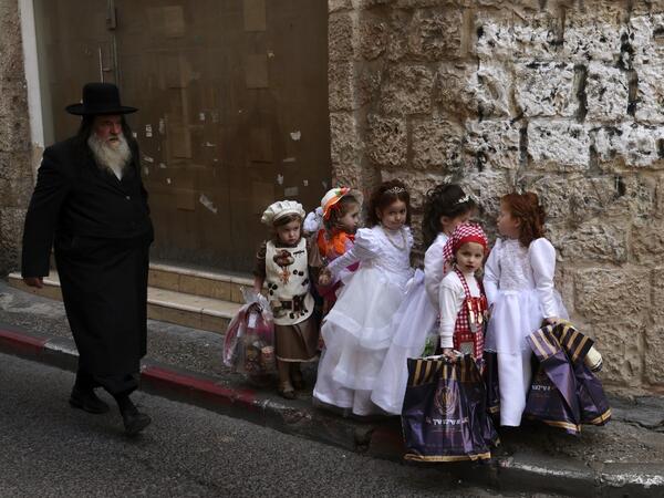 Ultra-Orthodox Jewish children dressed in costumes to celebrate Purim, walk in the street a day ahead of the official holiday, in the Mea Shearim neighbourhood in Jerusalem, on February 24, 2021. The carnival-like Purim holiday is celebrated with parades and costume parties to commemorate biblical story of the deliverance of the Jewish people from a plot to exterminate them in the ancient Persian empire , as recorded in the Book of Esther. MENAHEM KAHANA / AFP