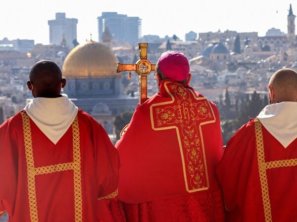 Latin Patriarch of Jerusalem Pierbattista Pizzaballa (C) holds a prayer during a Palm Sunday 