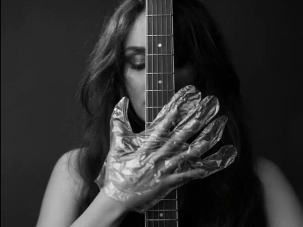 The musician in foil gloves is holding the instrument