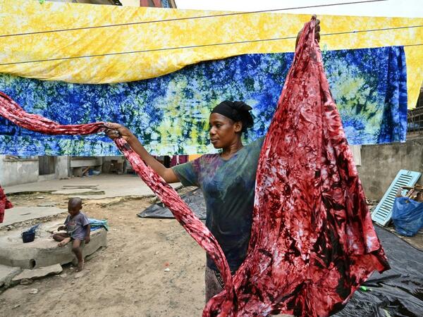 Dyers dye cotton fabric at Pathe'O house in the popular district of Treichville in Abidjan on March 31, 2021. 