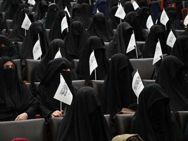 Afghan women wearing full face veils, pledging commitment to Taliban's policies on gender segregation