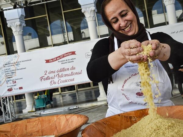 A woman prepares couscous during the 2nd edition of the International Couscous Festival at the Moufdi Zakaria Palace of Culture in the Algerian capital 
RYAD KRAMDI / AFP