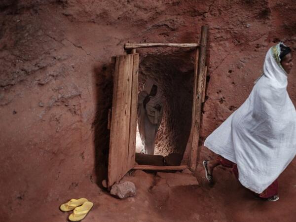 Ethiopian Orthodox devotees enter inside a tunnel leading to the rock-hewn church of Saint Emmanuel, in Lalibela, Ethiopia 
EDUARDO SOTERAS / AFP