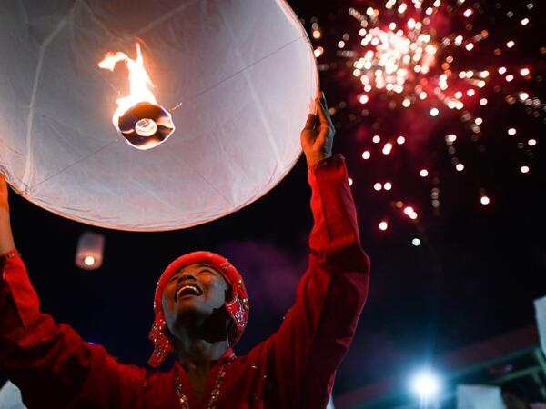A man releases lantern as fireworks explode over a makeshift palace during abbot Kay Lar Tha's funeral in Mudon, Mon State. 
Ye Aung THU / AFP