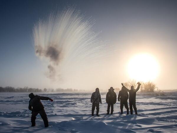 A villager throws hot water into the air while harvesting ice from a local lake near the settlement of Oy, some 70 km south of Yakutsk, with the air temperature at about minus 41 degrees Celsius. 
Mladen ANTONOV / AFP