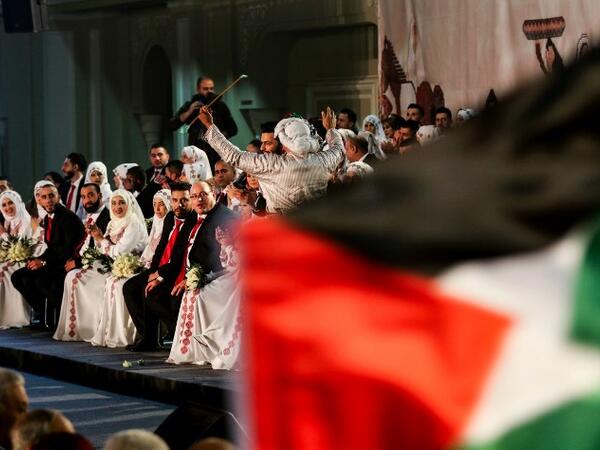 A man dressed in traditional Palestinian clothing dances during a mass wedding ceremony for 150 Palestinian couples and 50 other Lebanese couples, organised by PLO. Mahmoud ZAYYAT / AFP