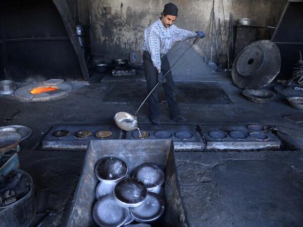 In this photo an Afghan labourer makes metal pots at an aluminum factory in Herat. 
HOSHANG HASHIMI / AFP