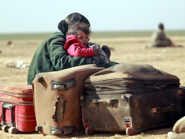 People who fled battles between Syrian Democratic Forces (SDF) and ISIS fighters in the Syrian village of Baghouz, arrive after crossing a desert in the back of a truck to a region controlled by the SDF in the countryside of the Deir Ezzor province, Delil SOULEIMAN / AFP