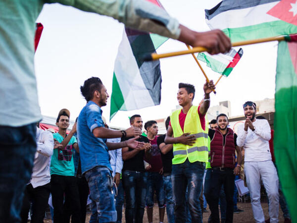Young Jordanians dance and wave flags at a political rally for an Islamist party in Amman on Sept. 10, 2016. (Lindsey Leger)