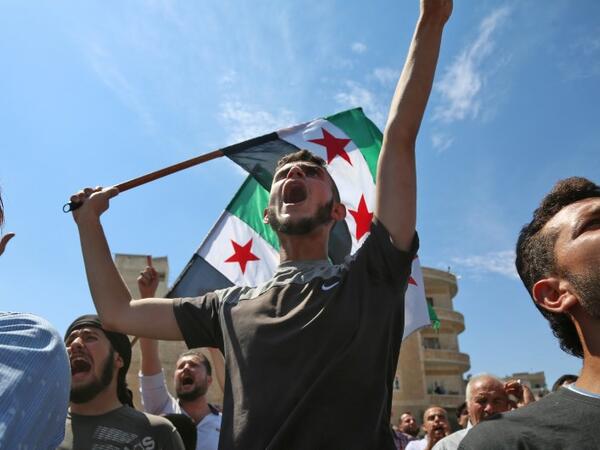 Syrian protesters wave the flag of the opposition as they demonstrate against the regime and its ally Russia, in the rebel-held city of Idlib on September 7, 2018. (Zein Al RIFAI / AFP)