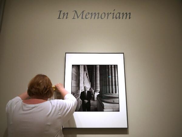 Smithsonian National Portrait Gallery Senior Graphic Designer Caroline Wooden hands a label next to a photograph of Sen. John McCain (R-AZ) August 27, 2018 in Washington. (AFP)
