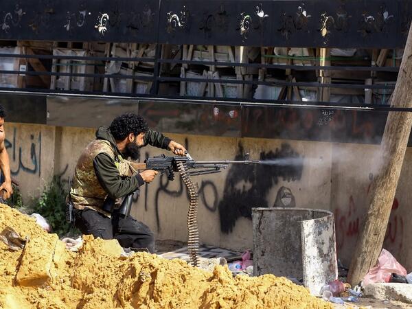 A Libyan fighter loyal to the Government of National Accord (GNA) fires a machine gun during clashes with forces loyal to strongman Khalifa Haftar south of the capital Tripoli's suburb of Ain Zara, on April 10, 2019.  Mahmud TURKIA / AFP