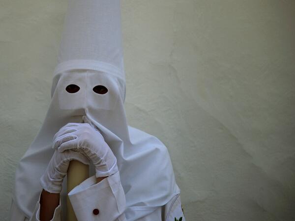 A penitent of the 'La Paz' brotherhood make their way to church for a Palm Sunday procession in Sevilla as part of the Holy Week on April 14, 2019.  CRISTINA QUICLER / AFP