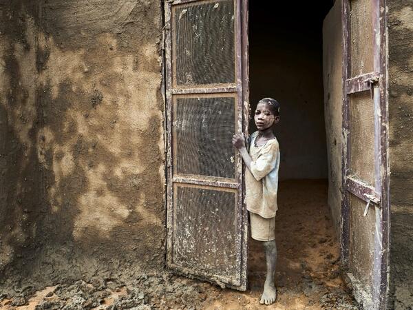 A boy stands at a door during the annual rendering of the Great Mosque of Djenne in central Mali  MICHELE CATTANI / AFP