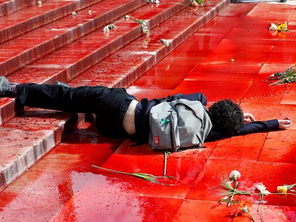A member of the action group Extinction Rebellion (XR) lies on the ground in fake blood on the Trocadero esplanade during a demonstration to alert on the state of decline of biodiversity, on May 12, 2019 in Paris. FRANCOIS GUILLOT / AFP