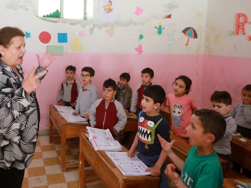 Antoinette Makh, instructs her pupils in the Aramaic language at a school in the Syrian mountain village of Maalula, in the Damascus region on May 13, 2019. LOUAI BESHARA / AFP