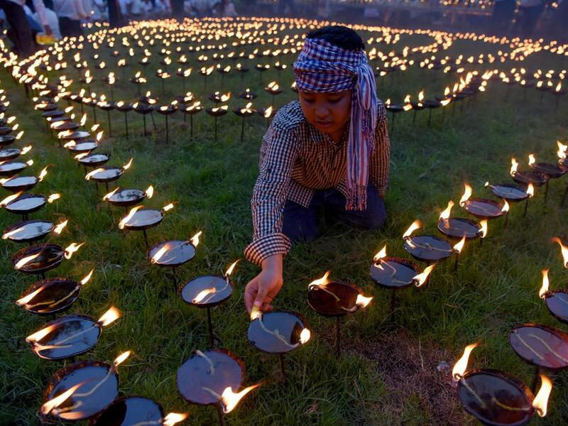 A Cambodian boy lights candles during the Visak Bochea Buddhist celebration at a pagoda in Phnom Penh on May 18, 2019. TANG CHHIN Sothy / AFP