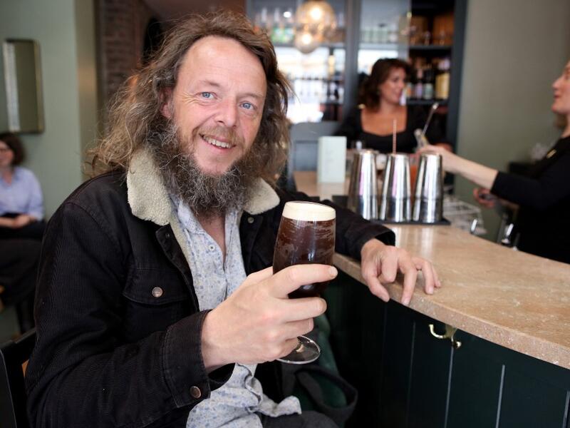 A patron poses with a non-alcoholic beer at the Virgin Mary pub, which opened recently selling non-alcoholic drinks and is known as the 'pub with no beer', in the city centre of Dublin on May 16, 2019. PAUL FAITH / AFP