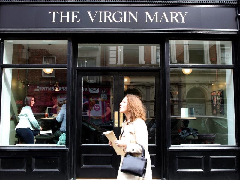 A woman walks past the Virgin Mary pub, which opened recently selling non-alcoholic drinks and is known as the 'pub with no beer', in the city centre of Dublin on May 16, 2019. PAUL FAITH / AFP