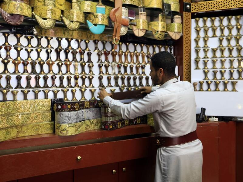A Yemeni vendor displays "janbiyas", traditionally-worn short curved daggers, in Sanaa on May 28, 2019 during the holy Muslim month of Ramadan and ahead of Eid al-Fitr celebrations.  Mohammed HUWAIS / AFP