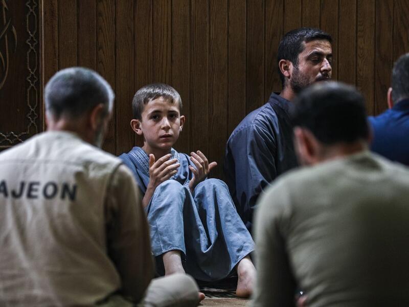 A young boy prays with other Muslim worshippers at a mosque in Maaret al-Noman in Syria's northwestern Idlib province early on June 1, 2019, on the occasion of Lailat al-Qadr, which marks the night in the fasting month of Ramadan during which the Koran was first revealed to Prophet Mohammed in the seventh century.  OMAR HAJ KADOUR / AFP