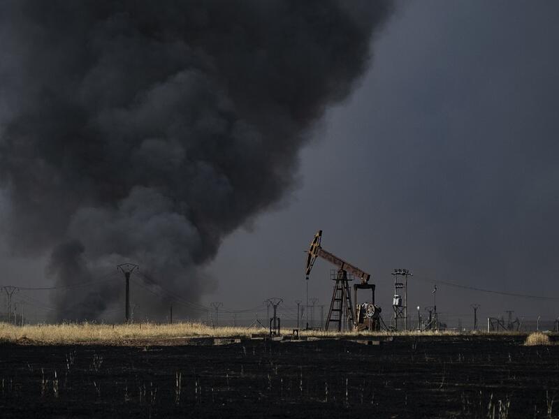 People battle a blaze next to an oil well in an agricultural field in the town of al-Qahtaniyah, in the Hasakeh province near the Syrian-Turkish border on June 10, 2019. Fires have erupted in various parts of Syria in recent weeks, with all sides blaming each other for starting them. Delil souleiman / AFP
