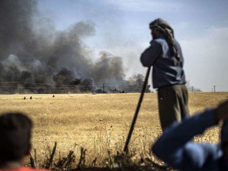 People battle a blaze next to an oil well in an agricultural field in the town of al-Qahtaniyah, in the Hasakeh province near the Syrian-Turkish border on June 10, 2019. Fires have erupted in various parts of Syria in recent weeks, with all sides blaming each other for starting them. Delil souleiman / AFP