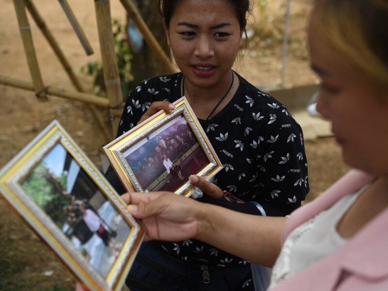 This picture taken on June 13, 2019 shows vendors selling souvenir photos near the entrance of the Tham Luang cave, in which 12 boys from the "Wild Boars" football team and their coach were trapped last year, in the Mae Sai district of Chiang Rai province. Lillian SUWANRUMPHA / AFP