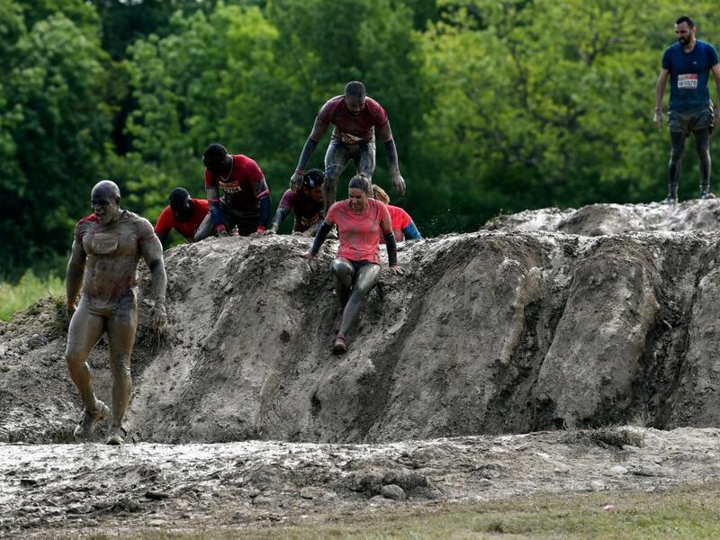 Runners cross an obstacle as they take part in the Mud Day, a 13km race with obstacles in Beynes, near Paris on June 16, 2019.  ALAIN JOCARD / AFP