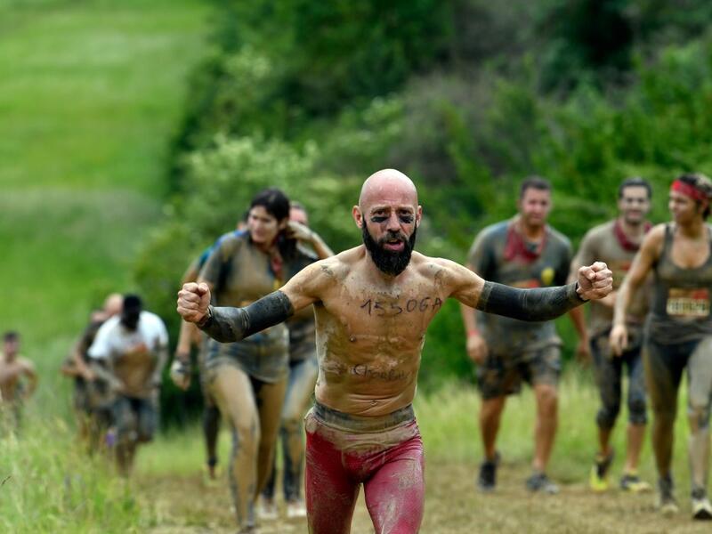 A runner gestures as he takes part in the Mud Day, a 13km race with obstacles in Beynes, near Paris on June 16, 2019.  ALAIN JOCARD / AFP