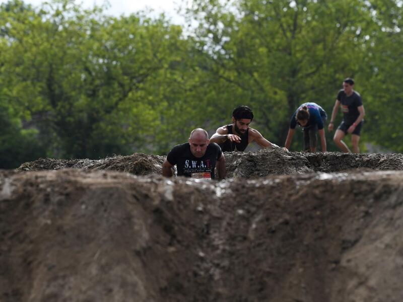 Runners cross an obstacle as they take part in the Mud Day, a 13km race with obstacles in Beynes, near Paris on June 16, 2019.  ALAIN JOCARD / AFP