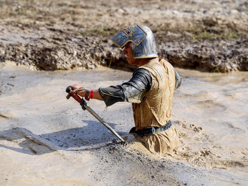 A runner wearing a medieval knight costume takes part in the Mud Day, a 13km race with obstacles in Beynes, near Paris on June 16, 2019.  ALAIN JOCARD / AFP
