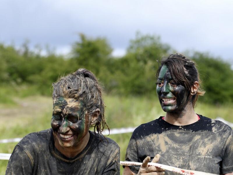 Runners wearing camouflage face paint react as they takes part in the Mud Day, a 13km race with obstacles in Beynes, near Paris on June 16, 2019.  ALAIN JOCARD / AFP