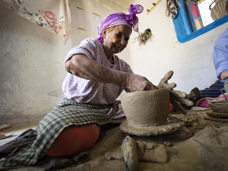 Moroccan potter Aicha Tabiz (L), also known as Mama Aicha, sits next to British apprentice Kim West (R), 33, during a pottery workshop near the village of Ourtzagh in the foothills of the Rif mountains on June 12, 2019. FADEL SENNA / AFP