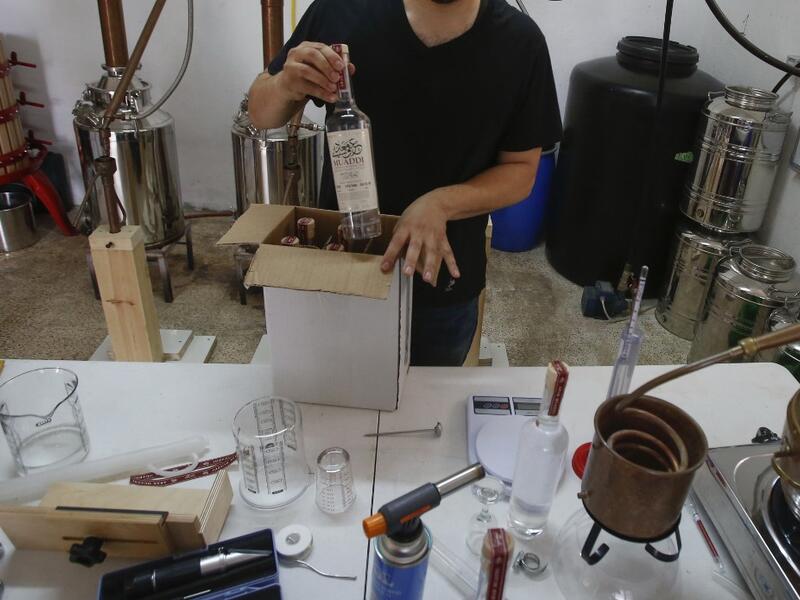 Palestinian distiller Nader Muaddi packages his Arak bottles in the West Bank village of Beit Jala, near Bethlehem, on June 16, 2019. In his basement, distiller Muaddi made fewer than 500 bottles of liquor last year, but it is earning global acclaim and reviving interest in the Palestinian alcohol sector. On the outskirts of the city famed for Jesus's birth, the 35-year-old illustrates the handcrafted way he makes Arak, an anise-flavoured drink popular in the Middle East and similar to Greek Ouzo, French Pa